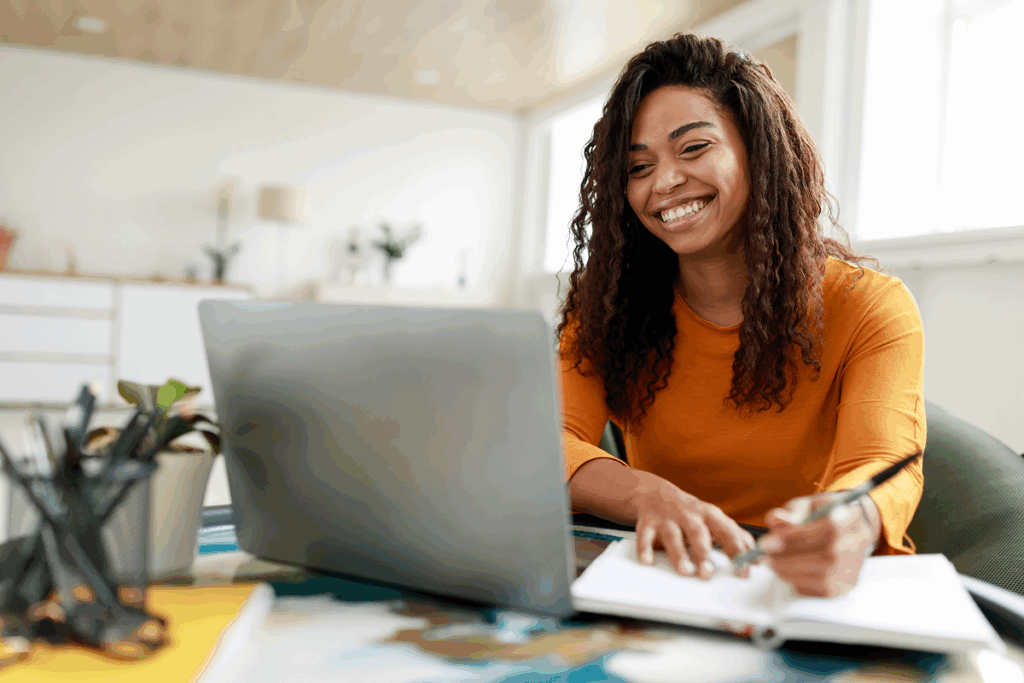 Mulher estudando usando o computador e sorrindo. Cursar duas pos graduações.