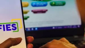 moça mexendo em celular com app do fies